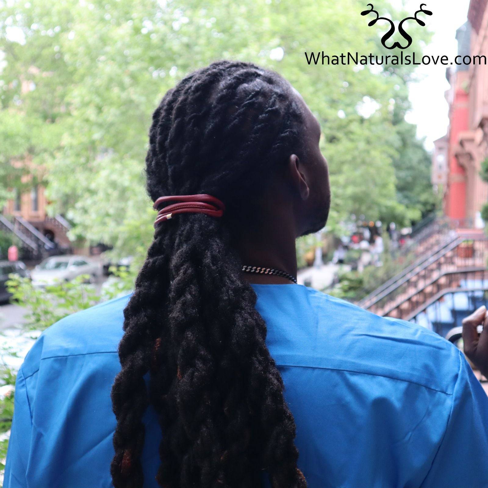Man with long dreadlocks tied with a red ponytail holder, standing outdoors. Non-damaging hair tie for locs, braids, and sisterlocks.