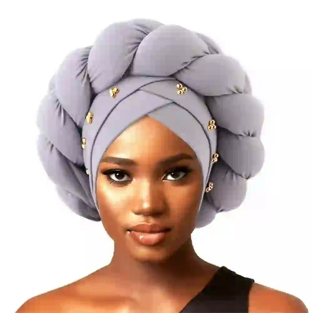 Gray Gele African turban for women featuring a braided design with gold bead accents. Stylish headwrap for cultural and fashion wear.