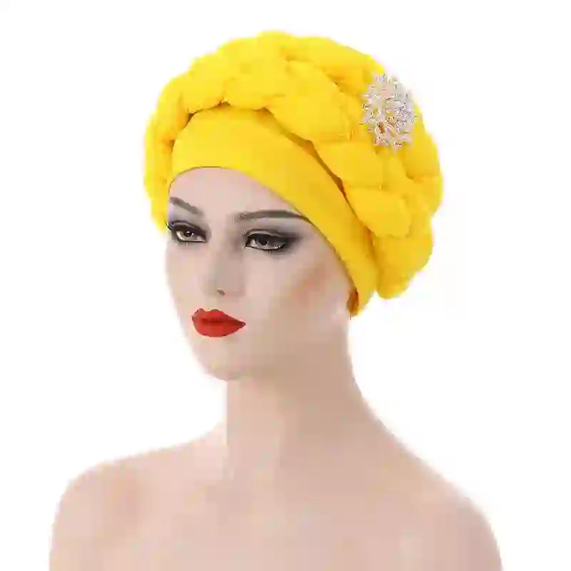 Mustard yellow Gele African turban with a silver brooch accent for women. A fashionable and elegant headwrap for special events.