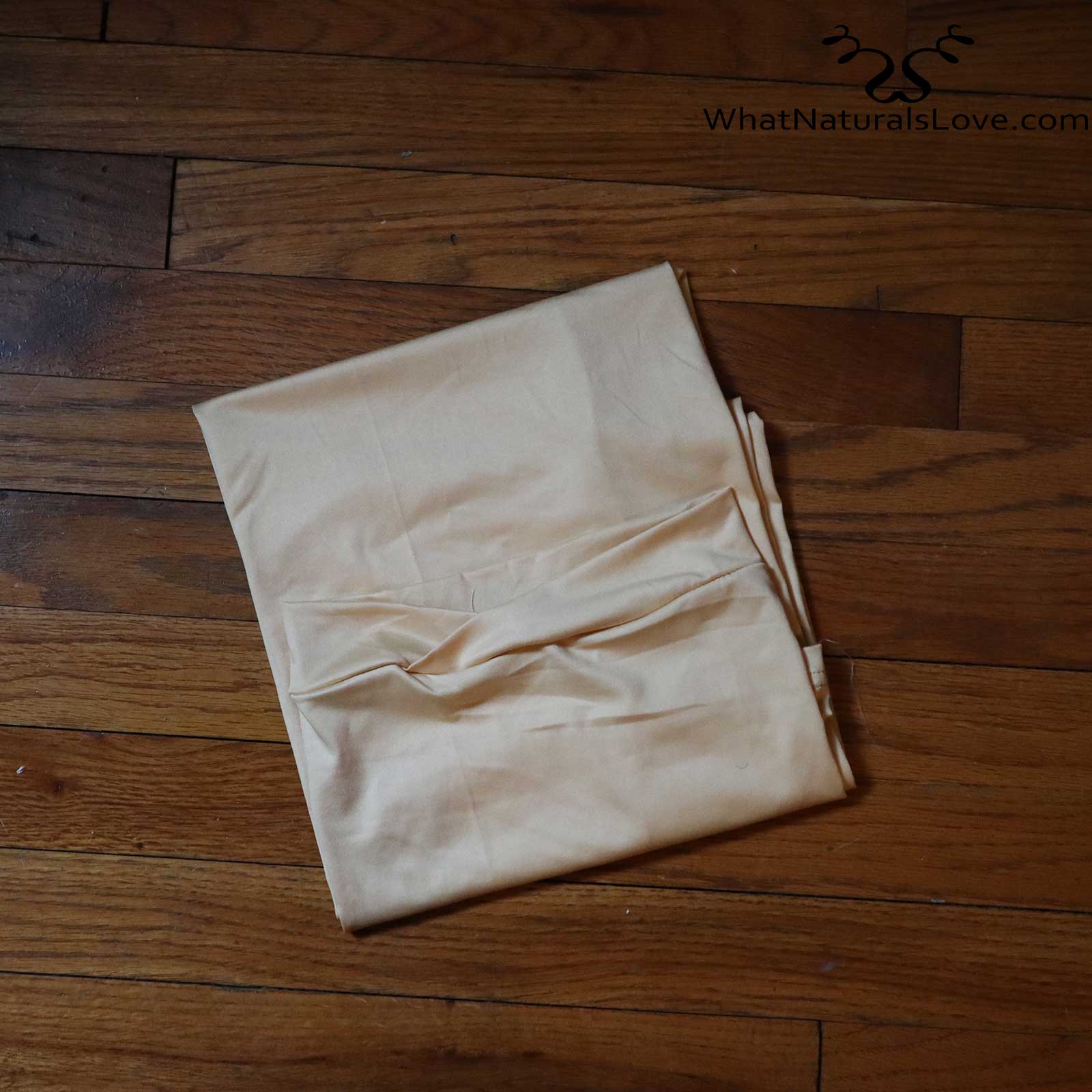 Folded beige tube headwrap for locs, sisterlocks, and dreadlocks. A neutral and stylish headwear option for natural hair.