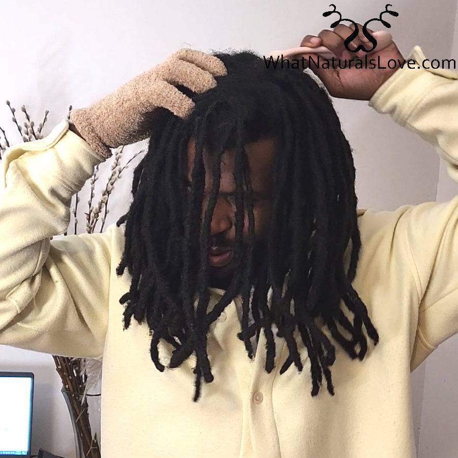 Close-up of scalp therapy using a cryotherapy roller to unclog pores and rejuvenate hair follicles for stronger locs.