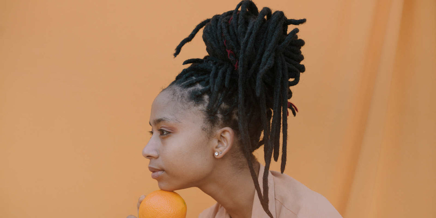 Vrouw met gezonde, gehydrateerde locs dankzij WNL Haar Serum