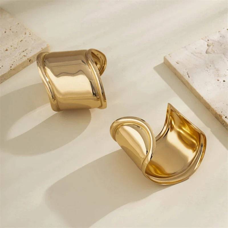 Stylish gold cuff bracelets with a modern, curved design. A chic accessory to enhance any outfit with a touch of elegance.