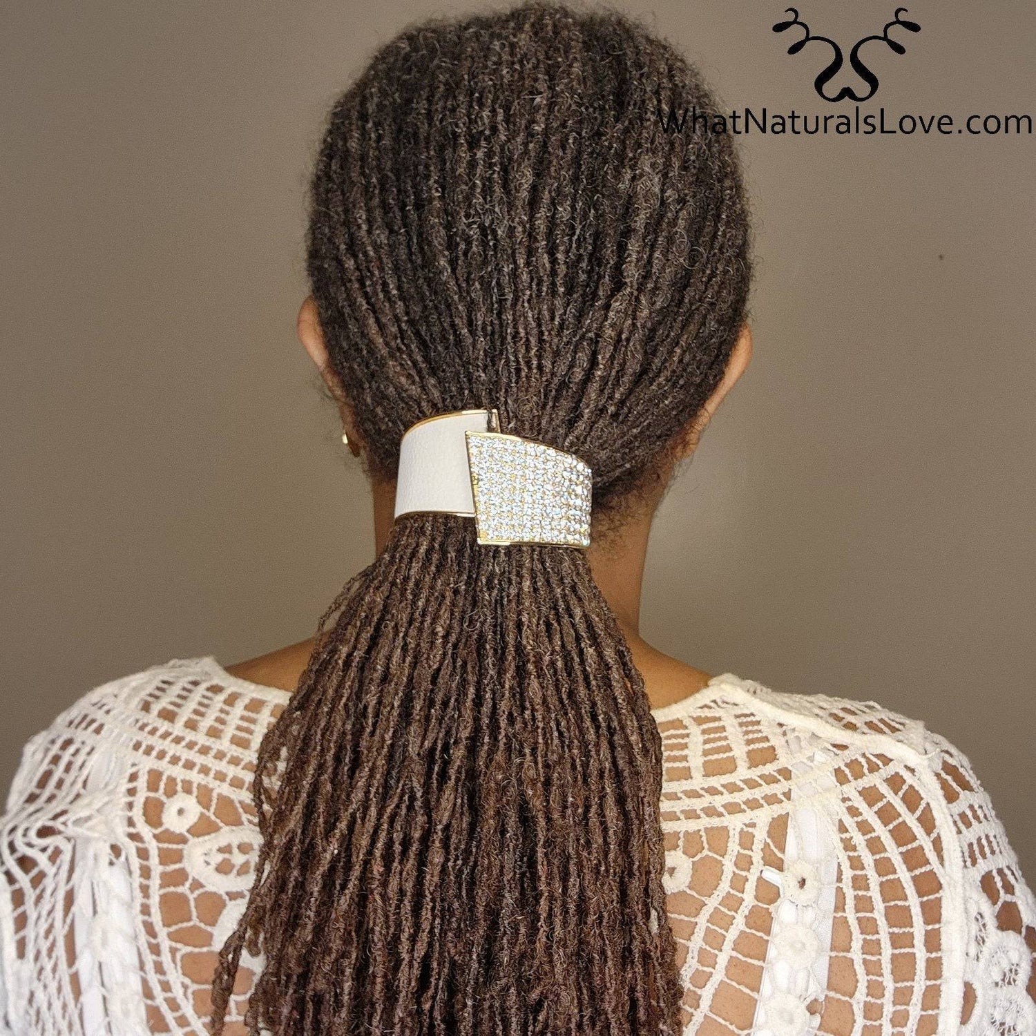 Woman wearing a rhinestone hair cuff securing her locs in a ponytail. A chic and non-damaging accessory for dreadlocks, braids, and curls.