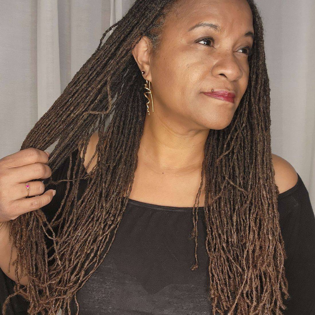 Woman with long, well-maintained locs after using the loc lint remover brush. Achieve cleaner, lint-free locs with this effective tool.