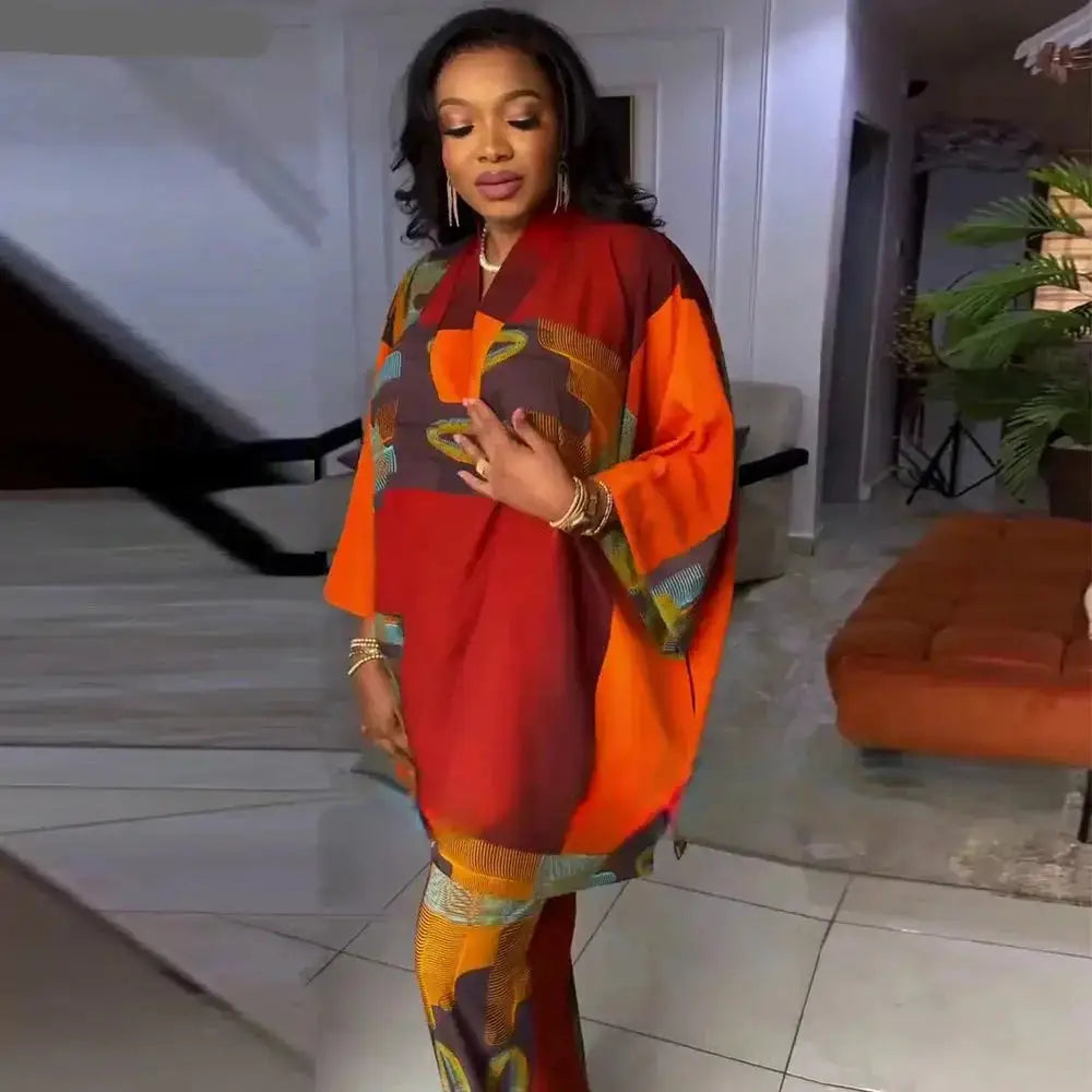 Chic two-piece outfit with a bold orange and multicolor abstract print, featuring a loose-fitting top and matching pants.