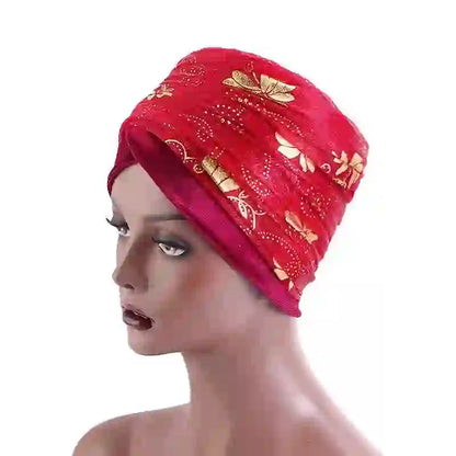 Red Regal Amethyst Adorned Headwrap featuring gold floral designs, elegantly wrapped on a mannequin. A fashionable headwear choice for women.