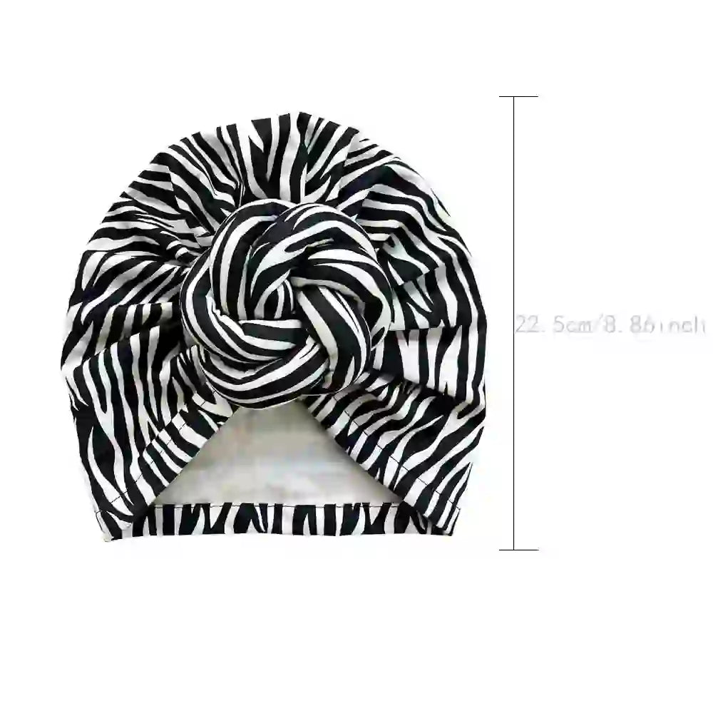 Black and white zebra-striped patterned knot turban headwrap with dimensions marked at 22.5 cm (8.86 inches) for size reference.