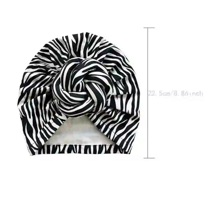 Black and white zebra-striped patterned knot turban headwrap with dimensions marked at 22.5 cm (8.86 inches) for size reference.