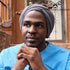 Man wearing an extra-large breathable wrap for locs and dreadlocks in gray. The stretchy headwrap provides a stylish and comfortable fit.