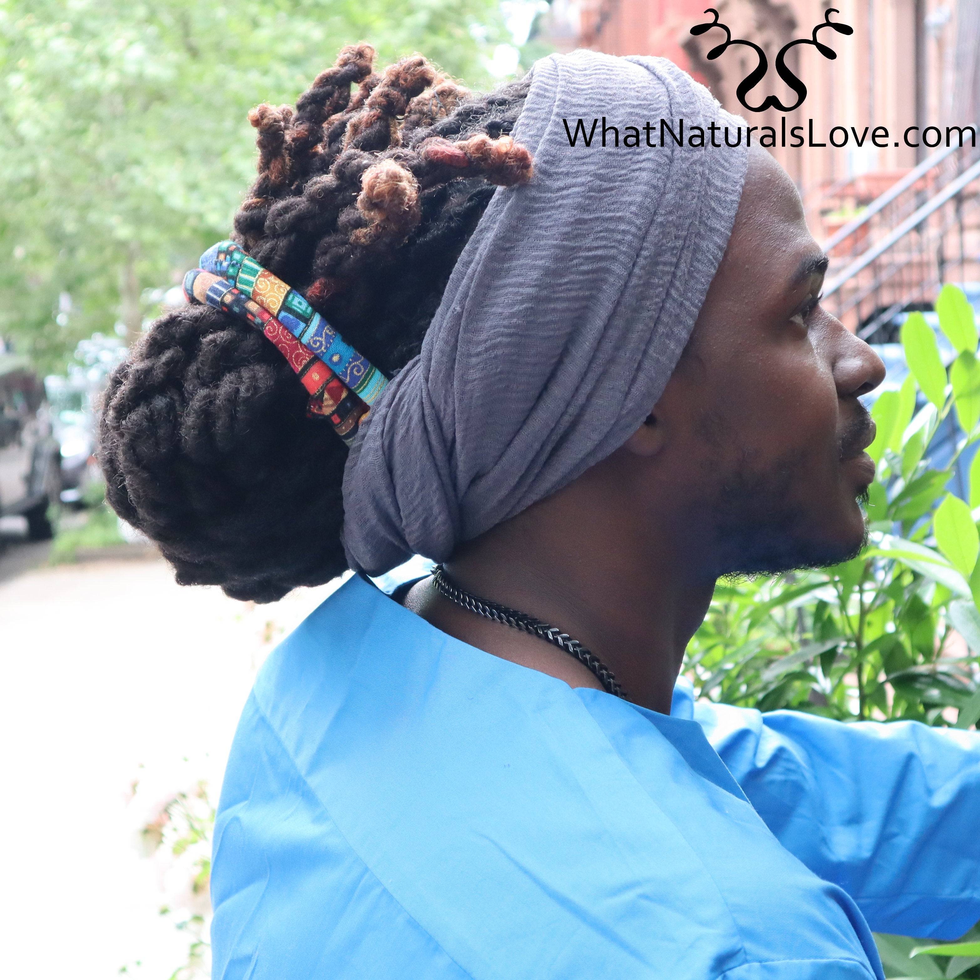 Man with dreadlocks tied up using a gray breathable wrap and colorful hair accessories. The large scarf provides a secure and stylish fit.