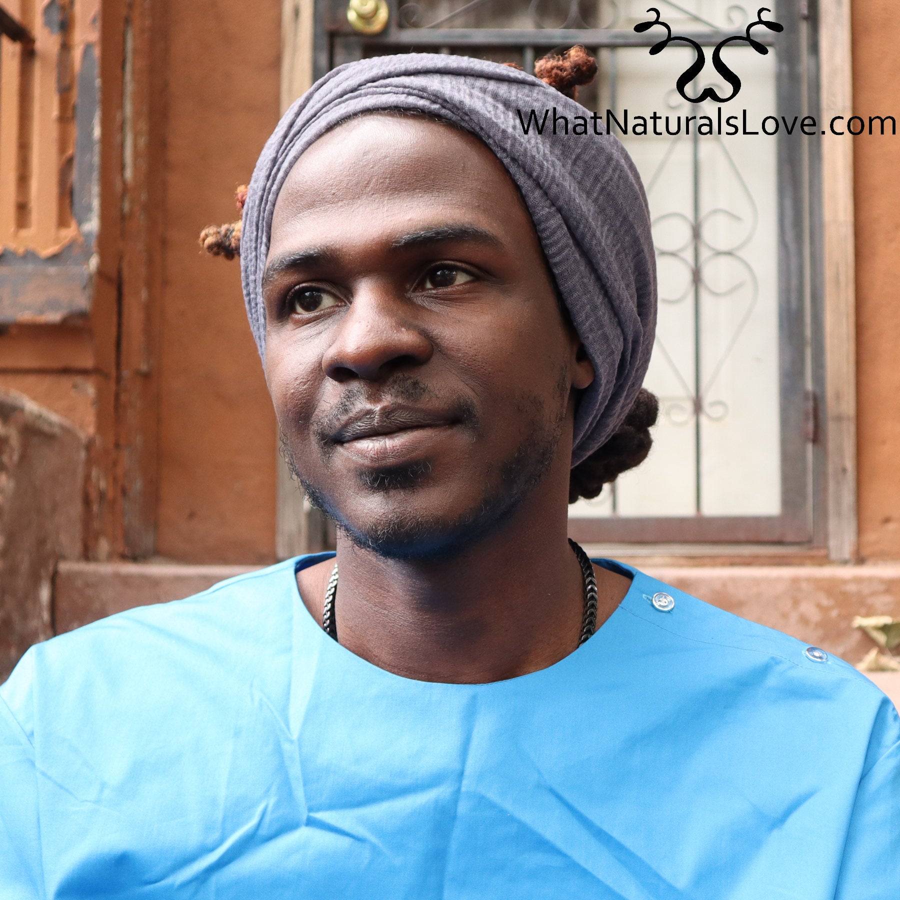Side view of a man wearing a breathable wrap for locs and dreadlocks. The large headwrap secures his hair stylishly and comfortably.