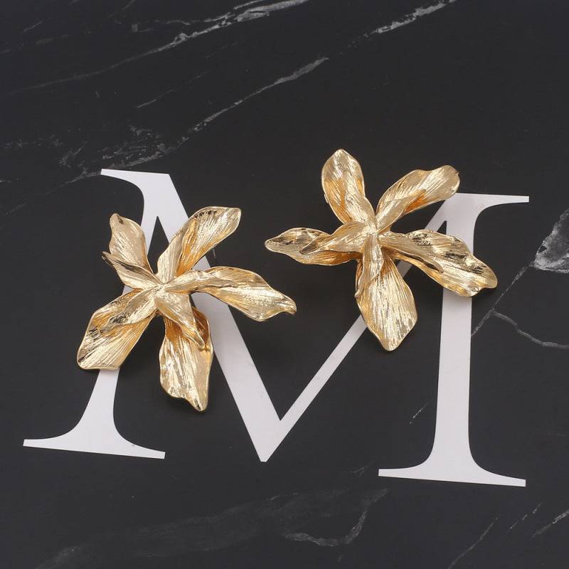 Kadija Luxe Bloom Earrings displayed on a black marble background, emphasizing their intricate floral design and luxurious gold finish.
