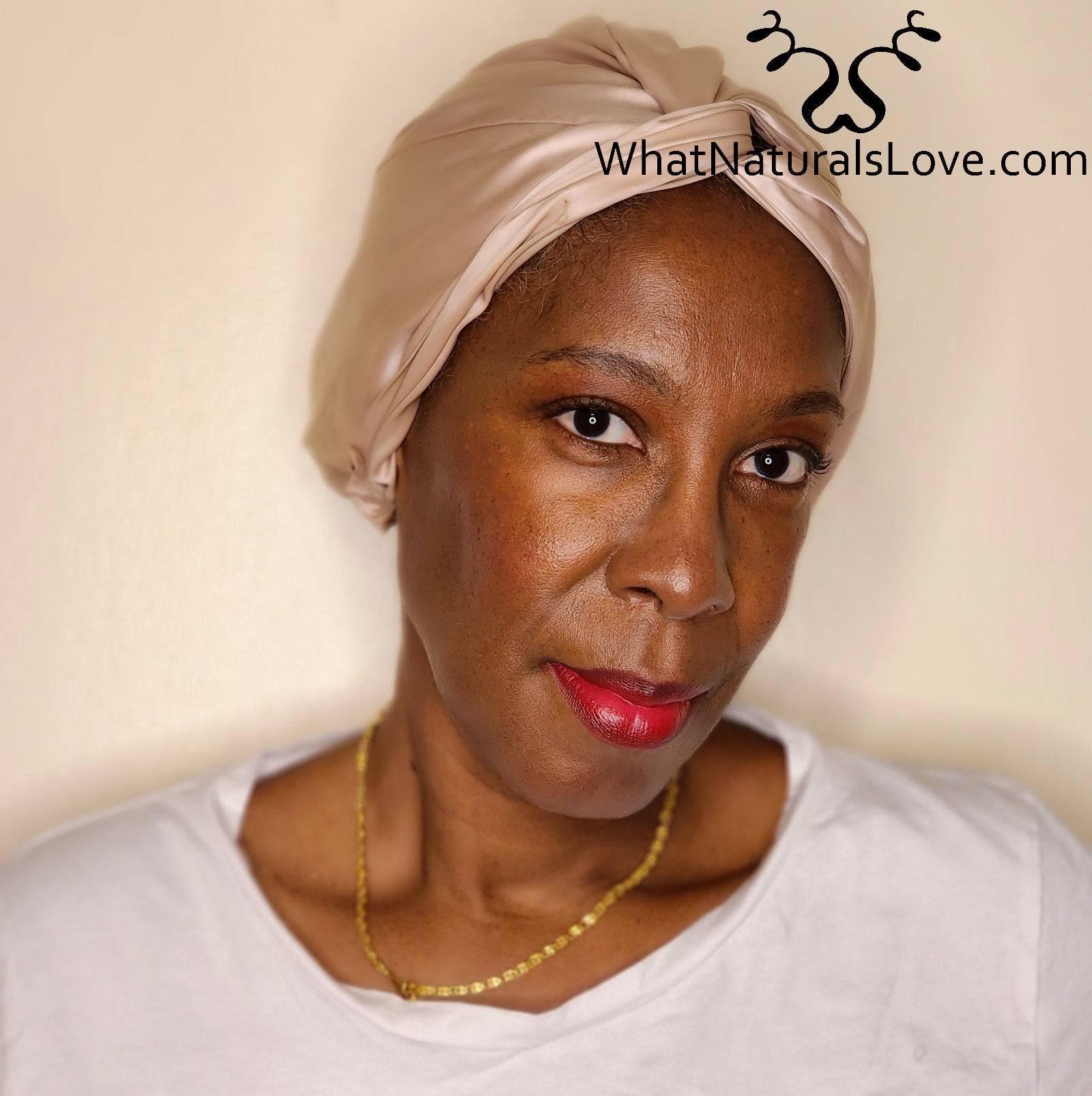 Close-up van een vrouw met een beige zijden kapje van What Naturals Love. Helpt de locs te beschermen en de hydratatie &